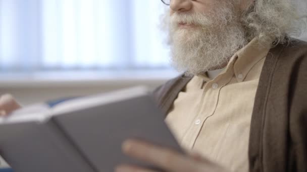 Starszy Dziadek Uśmiechnięty Czytający Książkę Domu Podnoszący Ogólną Wiedzę — Wideo stockowe