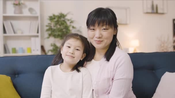Любящая Азиатская Мать Нежно Обнимает Маленькую Дочь Улыбается Камеру Вместе — стоковое видео