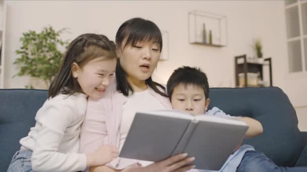 Madre Cariñosa Leyendo Libro Hijo Hija Familia Disfrutando Del Ocio — Vídeo de stock