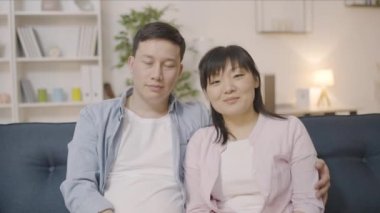 Asyalı bir çiftin portresi. Sarılma ve gülümseme. Uyumlu bir ilişki.