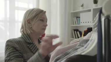 Moda stüdyosunda gömlek seçen mutlu müşteriler, kadın kıyafetleri, koleksiyon