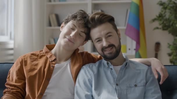 Glückliches Homosexuelles Paar Lehnt Köpfe Zusammen Sitzt Auf Couch Gleichgeschlechtliche — Stockvideo