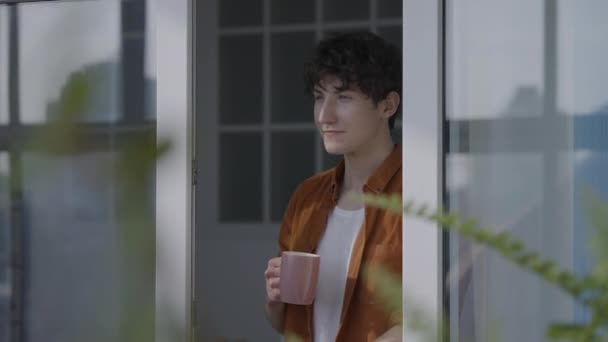 Zainspirowany Młody Człowiek Pijący Poranną Kawę Przez Okno Zadowolony Nowego — Wideo stockowe