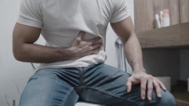 Erkek keskin mide ağrısı, tuvalette oturmak, gıda zehirlenmesi, hazımsızlık.