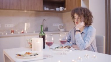 Yalnız kız arkadaş romantik yemek masasında oturmuş, kocasını bekliyor, sorun var.