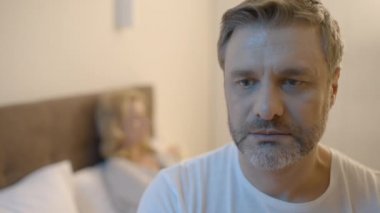 Stresli orta yaşlı bir adam yatakta oturuyor, libidosu düşük, mutsuz bir evliliği var.