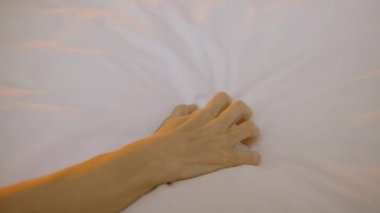 Erkek ve kadının elleri birbirine dolanmış, yatakta, tutkuda, sevişmede