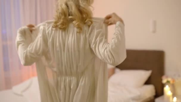 女性は怠慢を脱いで夫にベッドで待ってるロマンチックな夜 — ストック動画