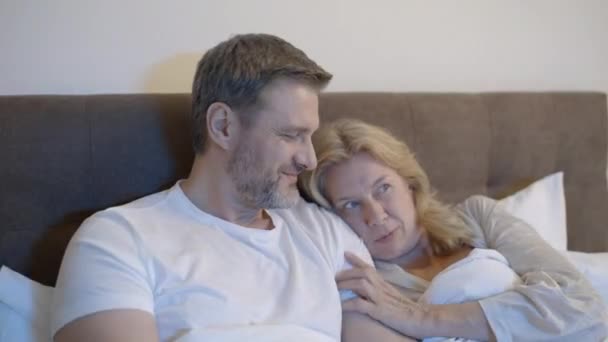 成双成对地在床上看恐怖片 害怕的妻子拥抱着丈夫 — 图库视频影像