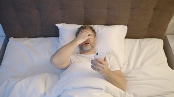 Schlafloser Erwachsener Mann Liegt Nachts Bett Und Scrollt Smartphone Schlaflosigkeit — Stockvideo