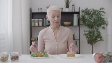 Güzel bir kadın pastayı reddediyor, taze salata yiyor, sağlıklı beslenmeyi seçiyor.