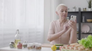 Sıska kadın akıllı telefonda kalori alımı hesap makinesi uygulaması kullanıyor, sağlıklı beslenme
