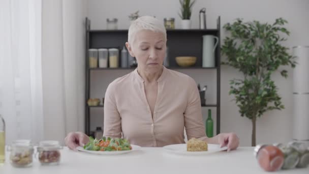 Donna Triste Mezza Età Che Sceglie Tra Insalata Sana Torta — Video Stock