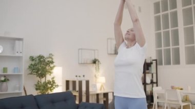 Evde yoga egzersizi yapan aktif, olgun bir kadın. Sağlıklı yaşam tarzı, fitness.