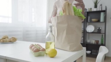 Dükkan fişini ve bakkal siparişini kontrol eden ciddi bir kadın, teslimat servisi.