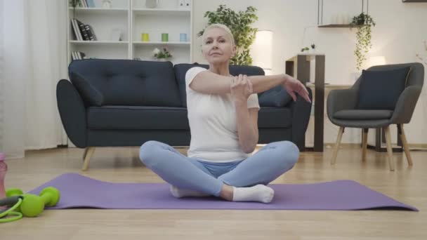 适合成熟女人伸展手臂肌肉 以莲花姿势坐着 瑜伽锻炼 — 图库视频影像