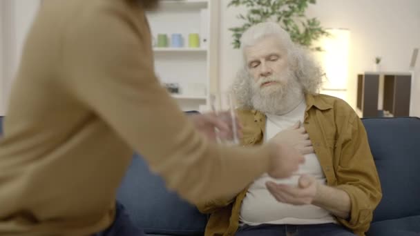 Pečující Syn Přináší Vodu Pilulky Pro Starší Otec Trpí Bolestí — Stock video