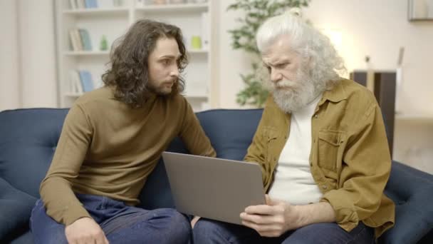 Staruszek Odmawiający Oferty Zwracający Laptopa Dorosłemu Synowi Złe Inwestycje — Wideo stockowe