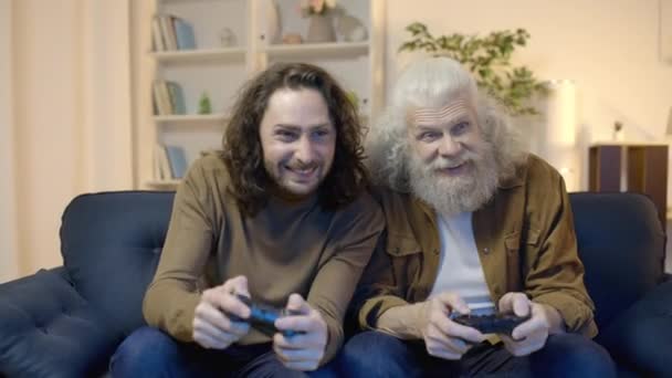 老人和儿子为电子游戏的胜利欢呼雀跃 彼此击掌 — 图库视频影像