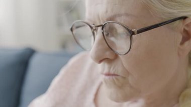 Gözlüklü kadın emekli evde örgü örüyor, el yapımı hobi, yakın plan.