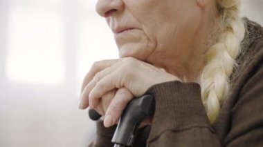 Rehabilitasyon merkezinde bastonu olan depresyondaki yaşlı kadın, fiziksel engelli.