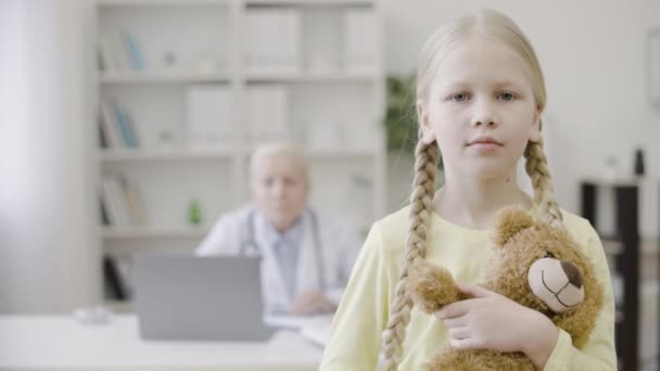 Smutna Dziewczynka Przytulająca Misia Patrząca Kamerę Badanie Lekarskie — Wideo stockowe