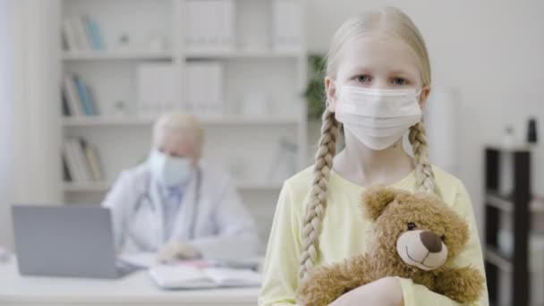 Fetiţă Tristă Mască Medicală Ţinând Ursuleţul Pluş Examenul Doctorului — Videoclip de stoc