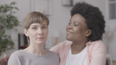 Aşık siyah kadın sevgilisini yanağından öpüyor, lezbiyen çift birlikte mutlu.