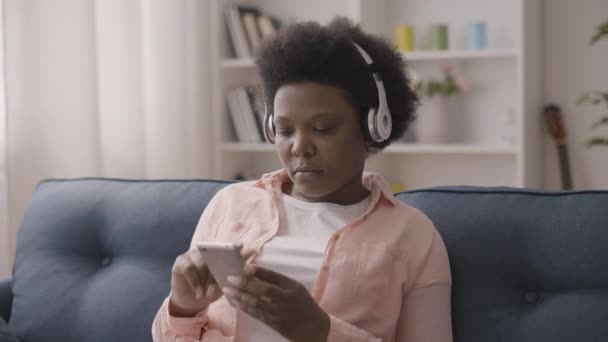 Fröhliche Afrikanerinnen Hören Musik Über Kopfhörer Mit Handy App Auf — Stockvideo
