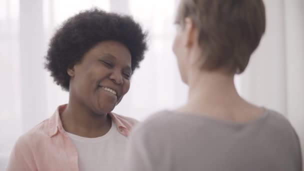黒人女性は笑顔で白人女性の友人を受け入れます 信頼関係 — ストック動画
