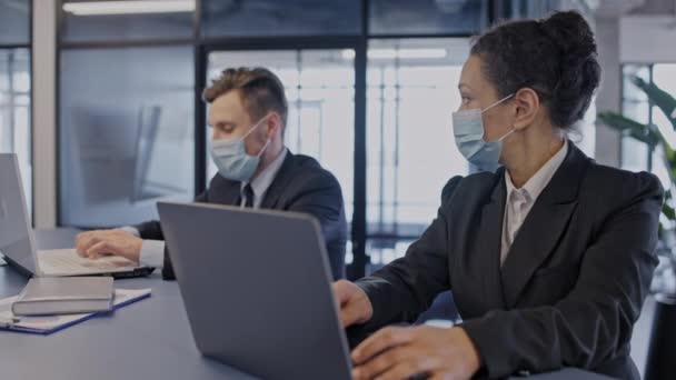 Dos Colegas Trabajando Computadoras Portátiles Oficina Usando Máscaras Faciales Seguridad — Vídeos de Stock