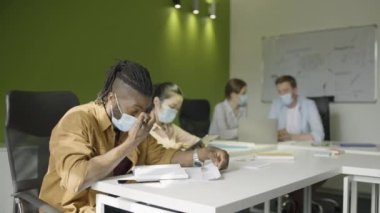 Covid-19 salgını sırasında koruyucu maskeler takan ofis çalışanları, önlemler