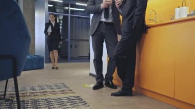 Erkek ofis çalışanları güzel bayan meslektaşlarının koridorlarına bakıyor.