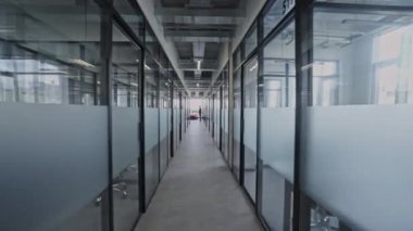 Birçok cam odası, modern çalışma alanı ve iş yeri olan uzun ofis koridoru.