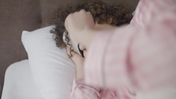 若い女性はしぶしぶ目を覚ますと眠りに戻る — ストック動画