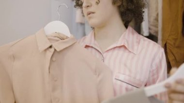 Pijamalı bir kadın dışarı çıkmak için doğru kıyafeti seçiyor, sabah rutini.