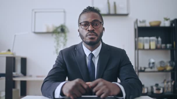 スーツを着たアフリカ系アメリカ人男性とオンライン通話を持つイヤホン 距離作業 — ストック動画