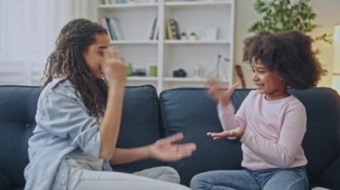 Siyah kardeşler evde taş kağıt makas oynuyorlar, küçük kız oyunu kaybediyor.