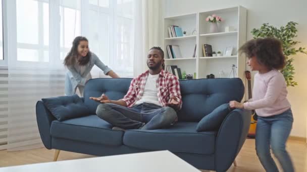 Afrikansk Far Sidder Yoga Udgør Sofaen Mens Døtre Kører Spiller – Stock-video