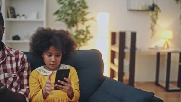 携帯電話で遊んでいるガジェット中毒の黒人家族ソーシャルメディアアプリを使って — ストック動画