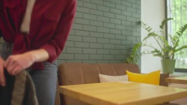 Kahve dükkanının masasında oturan ve kahve molası vermeye hazır bir kız öğrenci.