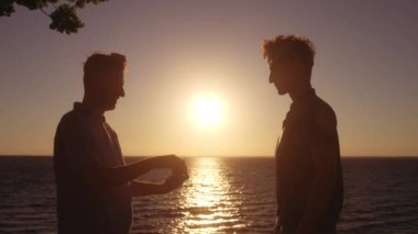 Deniz kenarındaki eşcinsel çift nişanı, aşık adam erkek arkadaşına evlenme teklif ediyor.