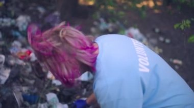 Kıdemli kadın çöp topluyor, gönüllü olarak doğal çevreyle ilgileniyor.