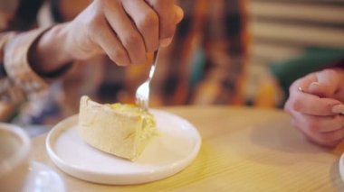 Sevgilisi tatlı bir tatlıyı güzel bir kız arkadaşla paylaşıyor, mutlu bir yüz ifadesi var.