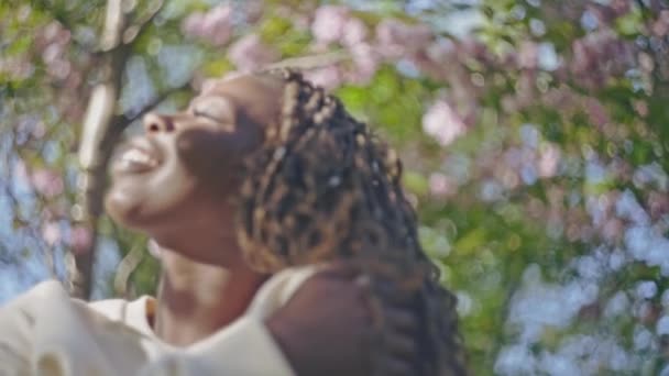 Hermosa Mujer Negra Disfrutando Del Sol Verano Bajo Árboles Florecientes — Vídeo de stock