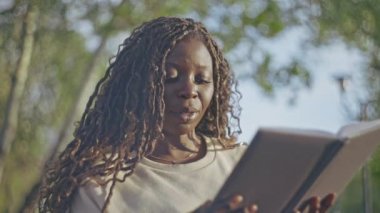 Afro örgülü, parkta kitap okuyan, hobisi olan ve dinlenen siyahi bir kadından esinlendim.