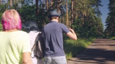 Bir grup neşeli erkek ve kadın arkadaş yol boyunca birlikte eğleniyorlar.