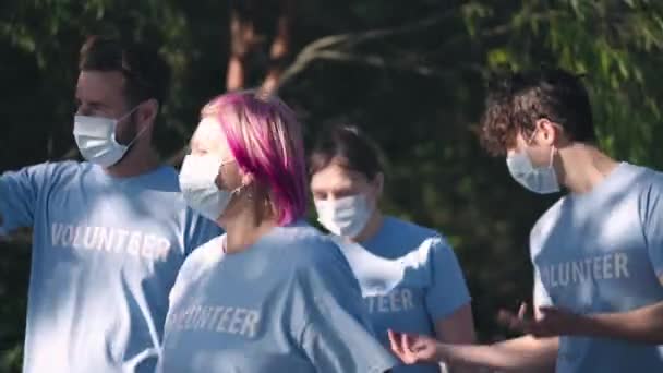 Kelompok Relawan Berjalan Taman Mengenakan Masker Wajah Mendiskusikan Tugas Bersama — Stok Video