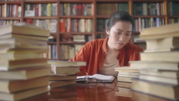 Εξαντλημένος Ασιάτης Φοιτητής Ιατρικής Ψάχνει Για Σωστό Βιβλίο Πάρα Πολύ — Αρχείο Βίντεο