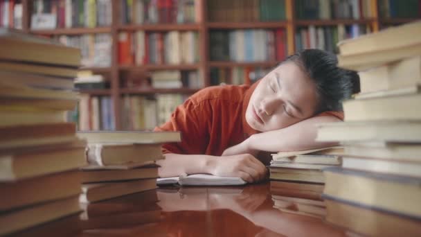 Yorgun Asyalı Öğrenci Kitap Yığınının Üzerinde Uyuyor Okumaya Ara Veriyor — Stok video